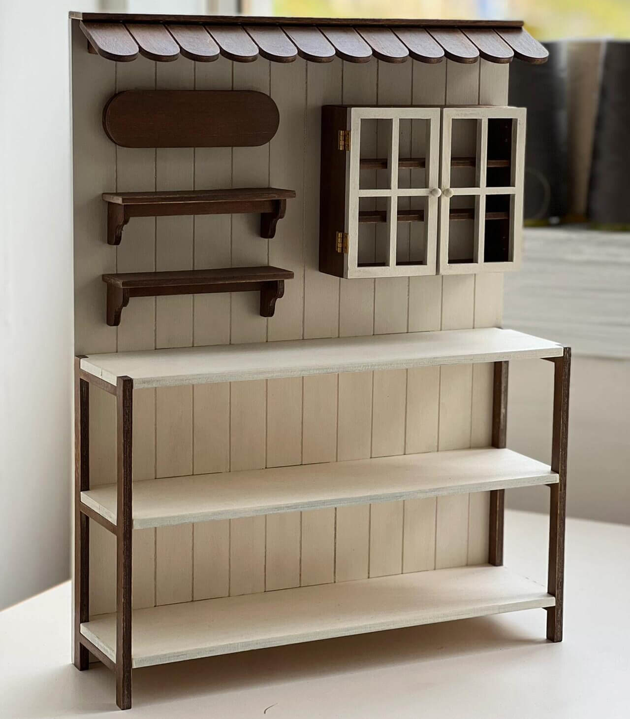 Add a charming touch of rustic elegance to your dollhouse with this Miniature Wooden Garden Shop Display Shelf Kit. Designed with intricate details, this piece features a classic garden shop look, complete with shelves for display and storage compartments. The roof adds a cozy, inviting feel, while the functional shelves are perfect for showcasing miniature plants, garden tools, and other tiny treasures.