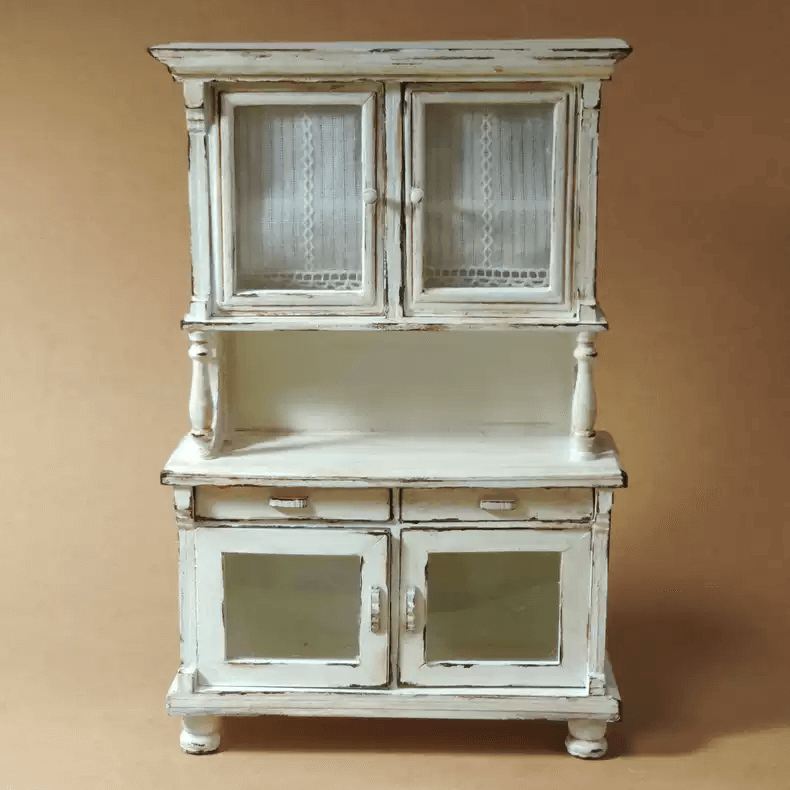 Add a touch of vintage elegance to your dollhouse with this Miniature Shabby Chic Kitchen Sideboard Cupboard Dresser Cabinet Kit. This beautifully crafted piece combines a charming sideboard with a cupboard and dresser, offering both display and storage options. The cabinet features doors for showcasing small items, while the lower section includes drawers for organizing your mini treasures.