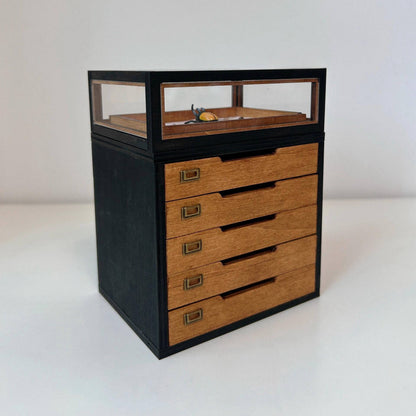 This miniature specimen cabinet is a beautifully crafted piece for displaying your butterfly and insect collections. Each of the six drawers can house specimen boxes, with the top transparent layer offering an ideal view to showcase your specimens. The matching specimen boxes can either be placed inside the cabinet or hung individually on the wall for a flexible display arrangement. Additionally, the vintage-style corkboard can be mounted on the wall, offering another option for showcasing items.