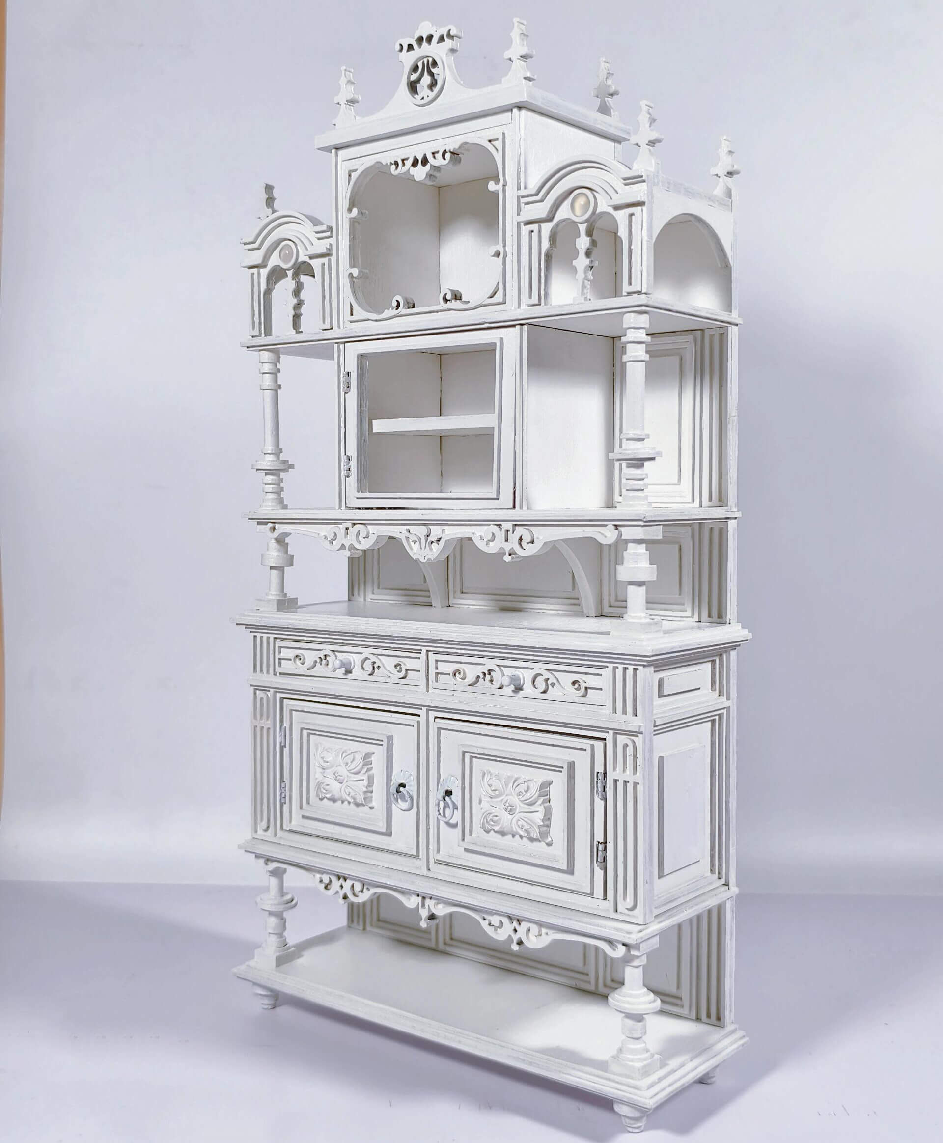 Enhance your dollhouse dining area with this Miniature Antique Buffet Cabinet with Carved and Shelves Kit. This beautifully crafted buffet features both open shelves for displaying miniatures and closed compartments for storage, all adorned with intricately carved decorative details and an elegant design. Available in various sizes, this buffet is perfect for showcasing fine dining accessories, storing dishes, or adding a sophisticated, vintage touch to your miniature kitchen or dining room.