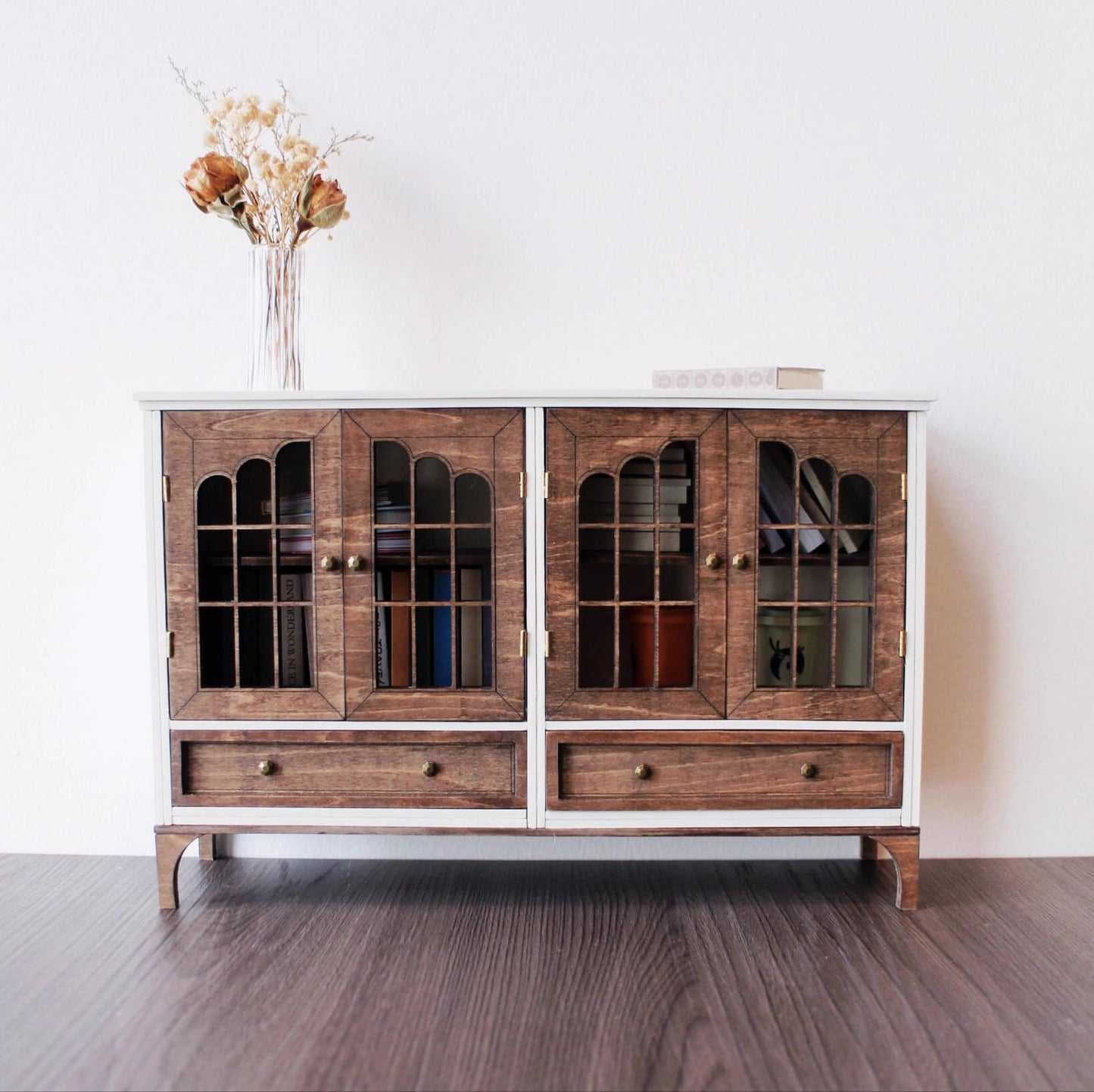 Add a classic touch to your dollhouse with this Miniature Wooden Sideboard with Doors and Drawers Kit. This beautifully designed sideboard features doors for displaying miniatures and small treasures, along with drawers for additional storage. The elegant wooden finish and handles give it a sophisticated, timeless look, making it a perfect addition to any dollhouse living room, dining room, or hallway.