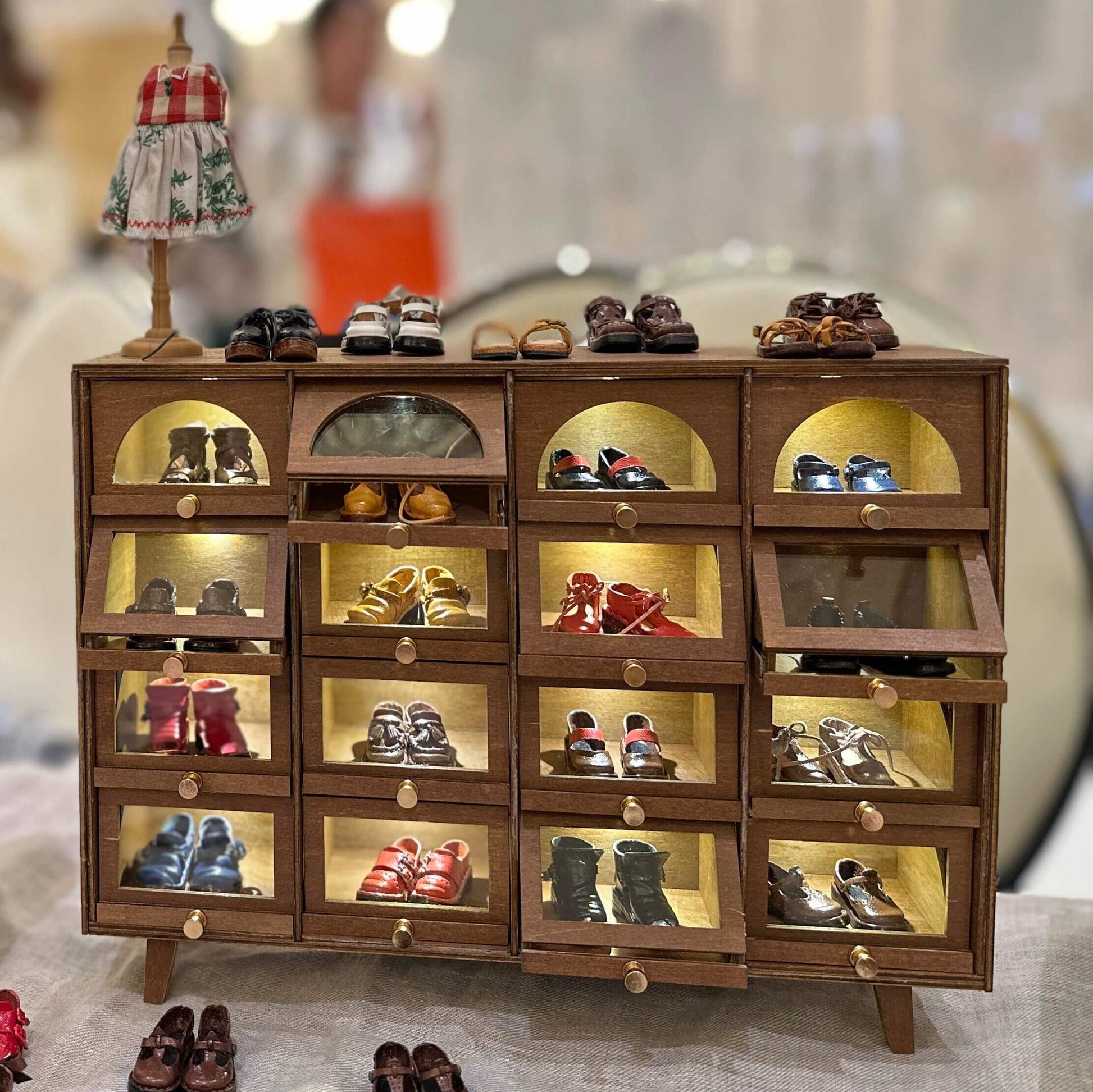 Elevate your dollhouse organization with our Elegant LED Wooden Shoes Showcase with Drawers, the perfect fusion of sophistication and practicality. Expertly crafted from high-quality wood, these boxes offer a timeless charm that enhances any room.