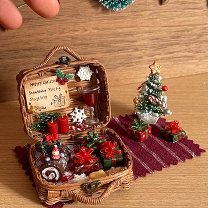 This festive miniature basket captures the magic of Christmas with incredible detail. Inside, you'll find tiny wrapped gifts, a cake, red candles, and a glass of wine, all arranged on a checkered cloth. The scene is complete with a mini Christmas tree and joyful holiday decorations, creating a cozy and enchanting holiday atmosphere.