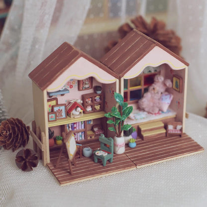 This foldable miniature dollhouse opens up to reveal two charming rooms filled with detailed, removable furniture. One side features an artistic studio with a cozy easel, plant decor, and a workspace, while the other side offers a relaxing bedroom with colorful pillows, a plush bed, and a vibrant window. Each piece, from the tiny bookshelves to the small plants, is meticulously crafted, making it an ideal addition for collectors or anyone who loves unique, interactive designs.