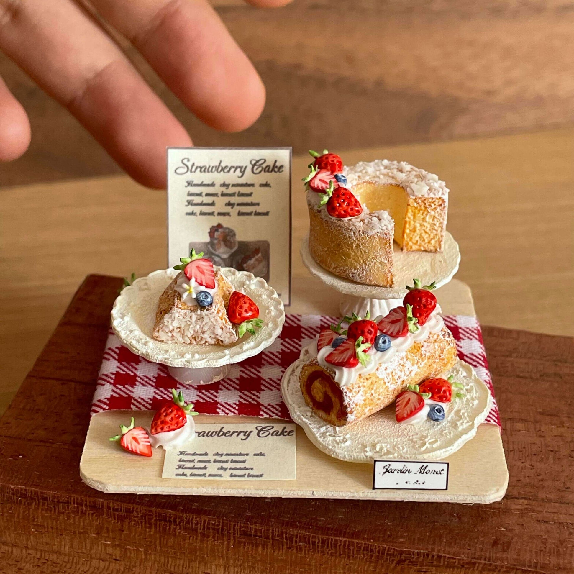 Indulge in our Miniature Strawberry Cake Set, a delightful addition to your dollhouse or miniature scene. All featuring a charming strawberry theme. Each piece is carefully made with high-quality materials to ensure realistic details and long-lasting beauty.