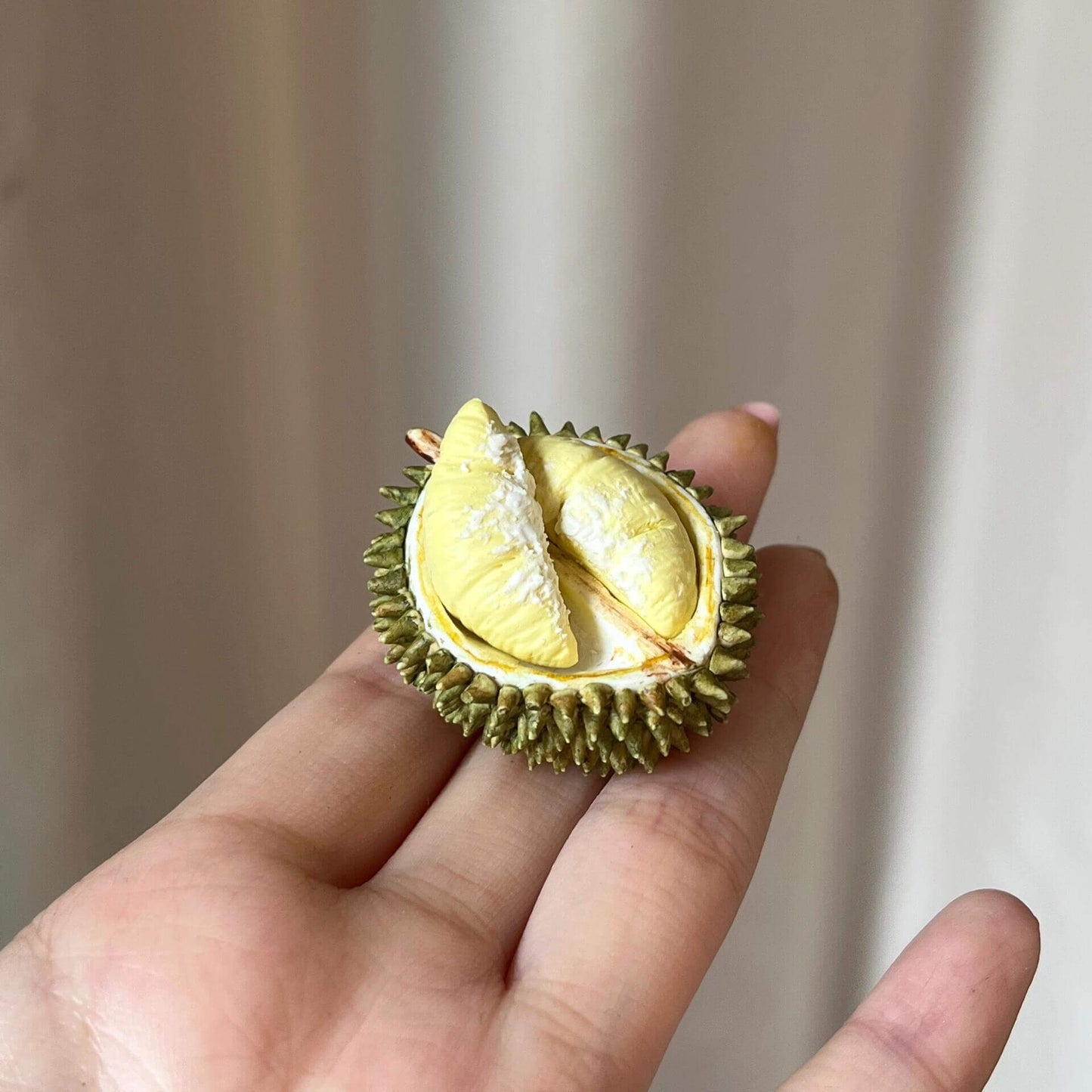 Miniature fruit half durian for a dollhouse. Miniature fruit half durian made of polymer clay. Miniature fruit half durian can be used in doll kitchen, doll grocery store, doll food, collection, diorama decoration.