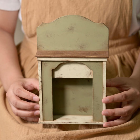 Add a cozy, rustic touch to your dollhouse with this Miniature Vintage Wooden Fireplace with Shelf Kit. Featuring a beautifully distressed design with a charming green and white finish, this fireplace includes a small shelf for displaying miniature decor, candles, or plants. It brings a warm, inviting atmosphere to any room, making it a perfect addition to your dollhouse living room or entryway.