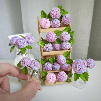 Hydrangeas are deciduous shrubs with flowers in terminal, round or umbrella-shaped clusters in colors of white, pink, or blue, or even purple.  Scale: 1:6; 1:12  Material: Handmade from Clay  Default Color: Random  A variety of colors are available, choose your favorite color and make a note.