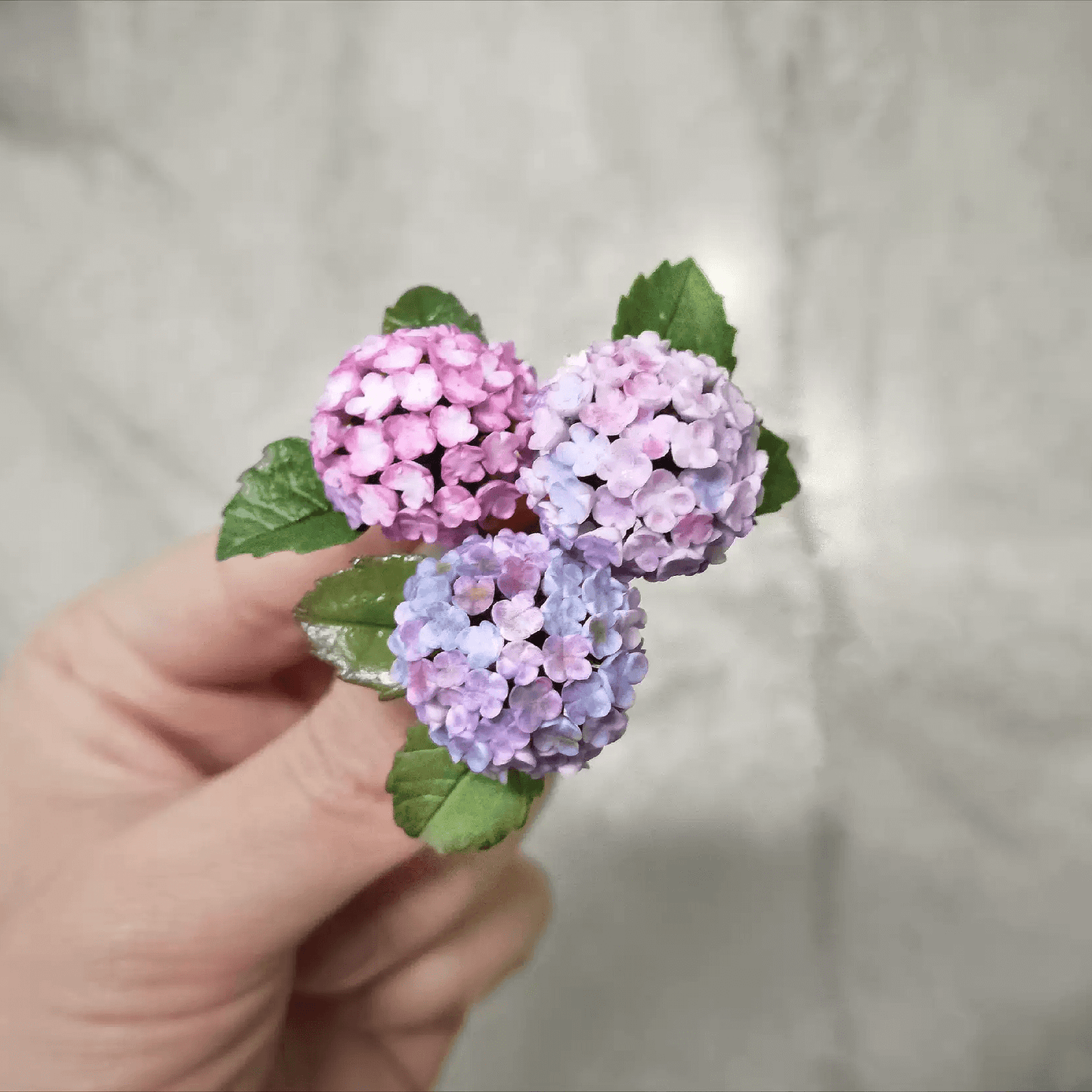 Hydrangeas are deciduous shrubs with flowers in terminal, round or umbrella-shaped clusters in colors of white, pink, or blue, or even purple.  Scale: 1:6; 1:12  Material: Handmade from Clay  Default Color: Random  A variety of colors are available, choose your favorite color and make a note.