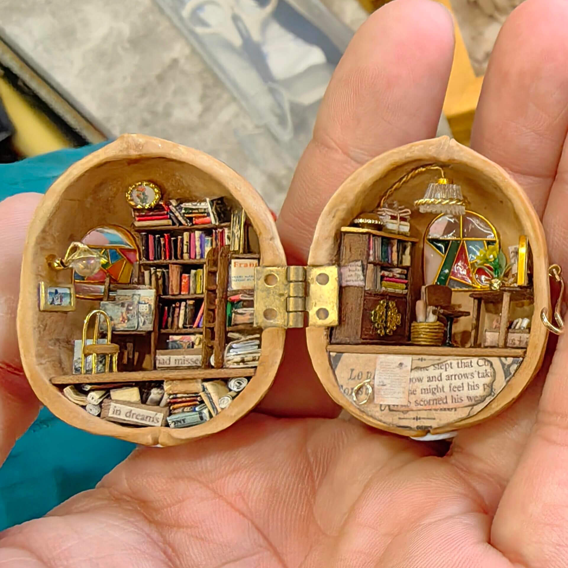 This is a beautifully detailed miniature library encased in a walnut shell. The scene features tiny bookshelves brimming with colorful books, a stained window, and intricate furniture pieces, creating a cozy and enchanting reading nook. The craftsmanship brings an entire story-filled world to life within the smallest of spaces.