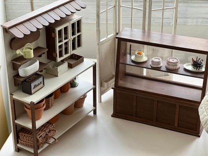 Add a charming touch of rustic elegance to your dollhouse with this Miniature Wooden Garden Shop Display Shelf Kit. Designed with intricate details, this piece features a classic garden shop look, complete with shelves for display and storage compartments. The roof adds a cozy, inviting feel, while the functional shelves are perfect for showcasing miniature plants, garden tools, and other tiny treasures.