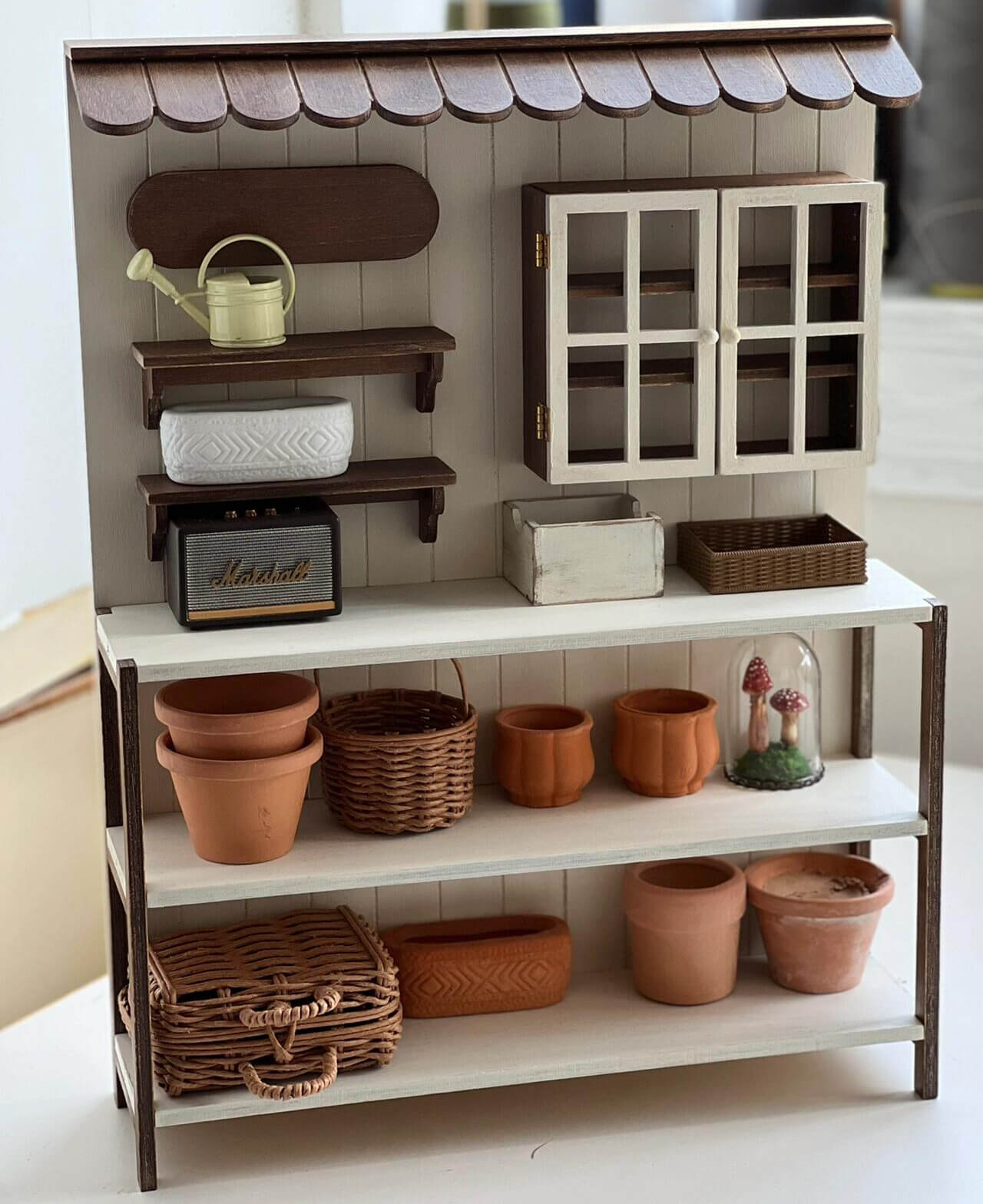 Add a charming touch of rustic elegance to your dollhouse with this Miniature Wooden Garden Shop Display Shelf Kit. Designed with intricate details, this piece features a classic garden shop look, complete with shelves for display and storage compartments. The roof adds a cozy, inviting feel, while the functional shelves are perfect for showcasing miniature plants, garden tools, and other tiny treasures.