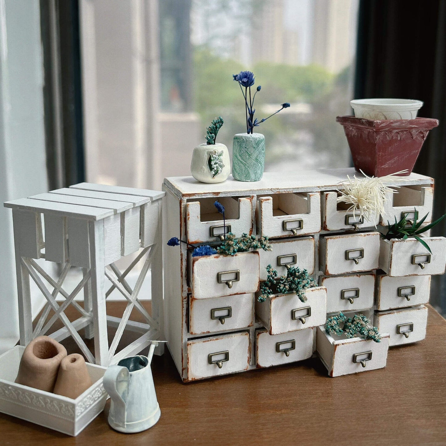 Bring a touch of rustic charm to your dollhouse with this Miniature Rustic Farmhouse Storage Drawer Cabinet Kit. Featuring 16 practical drawers, this beautifully crafted cabinet is ideal for organizing small items such as craft supplies, tiny plants, or decorative pieces. The farmhouse-inspired design with its whitewashed wood finish and vintage drawer pulls makes it a perfect addition to any miniature kitchen, living room, or garden space.