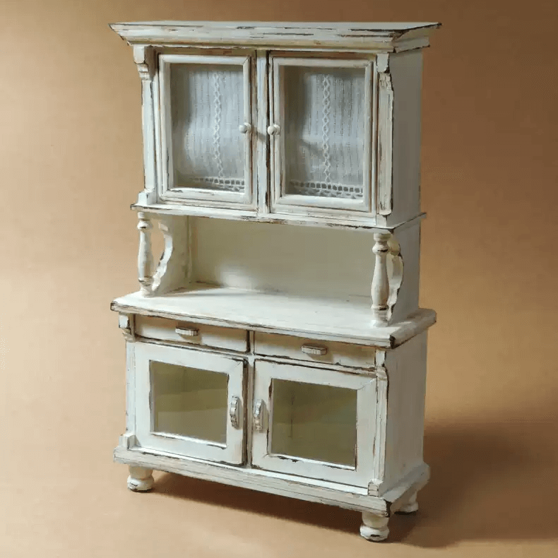 Add a touch of vintage elegance to your dollhouse with this Miniature Shabby Chic Kitchen Sideboard Cupboard Dresser Cabinet Kit. This beautifully crafted piece combines a charming sideboard with a cupboard and dresser, offering both display and storage options. The cabinet features doors for showcasing small items, while the lower section includes drawers for organizing your mini treasures.