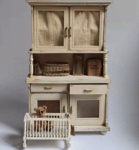 Add a touch of vintage elegance to your dollhouse with this Miniature Shabby Chic Kitchen Sideboard Cupboard Dresser Cabinet Kit. This beautifully crafted piece combines a charming sideboard with a cupboard and dresser, offering both display and storage options. The cabinet features doors for showcasing small items, while the lower section includes drawers for organizing your mini treasures.