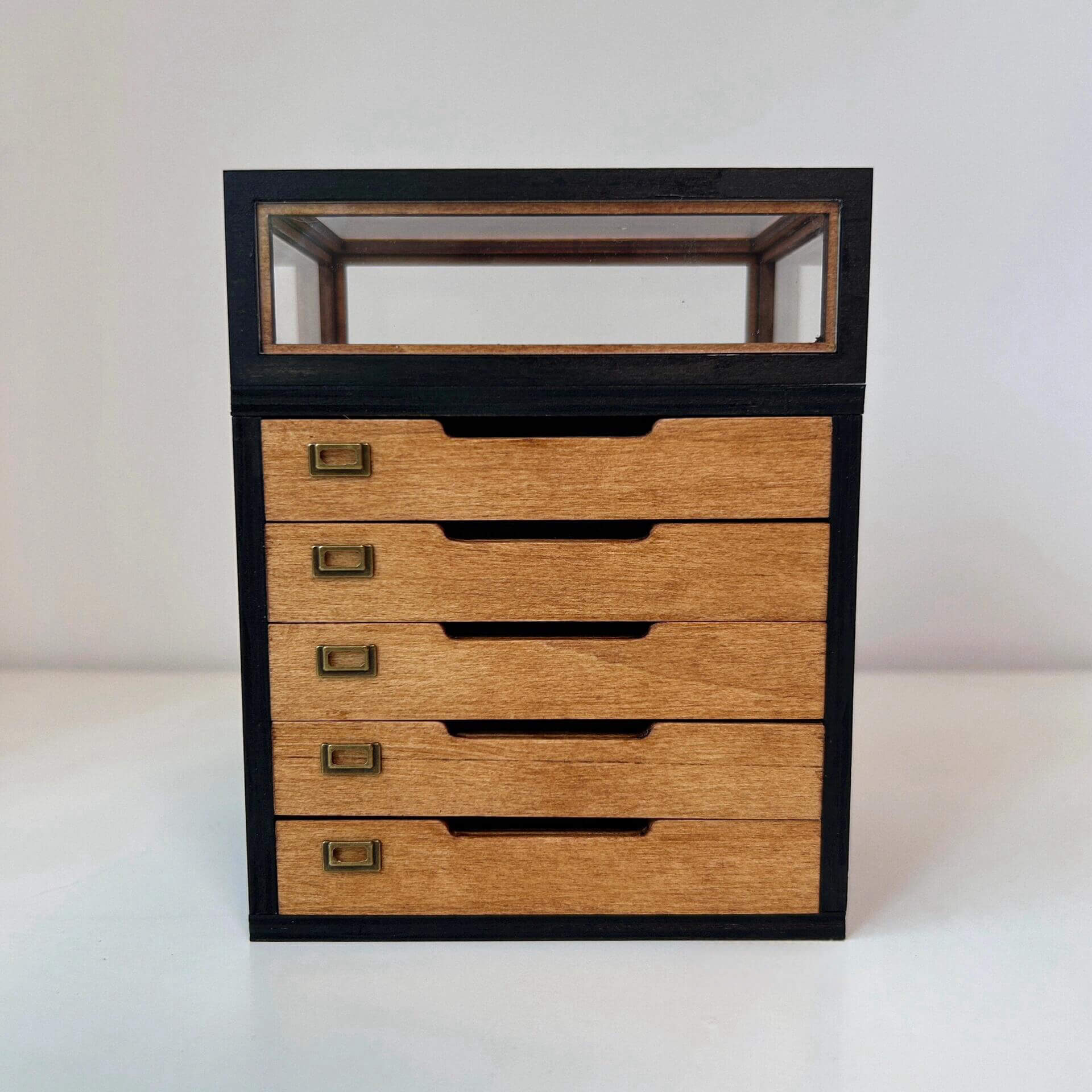 This miniature specimen cabinet is a beautifully crafted piece for displaying your butterfly and insect collections. Each of the six drawers can house specimen boxes, with the top transparent layer offering an ideal view to showcase your specimens. The matching specimen boxes can either be placed inside the cabinet or hung individually on the wall for a flexible display arrangement. Additionally, the vintage-style corkboard can be mounted on the wall, offering another option for showcasing items.