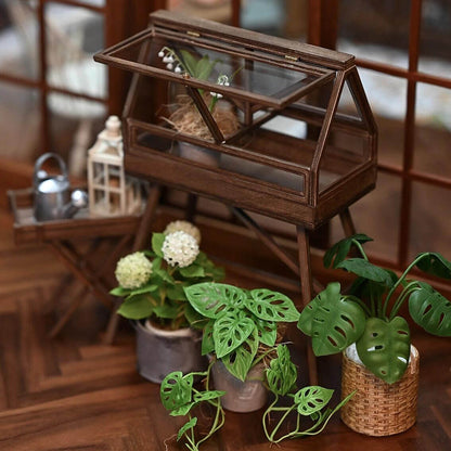 Bring a charming, rustic touch to your dollhouse garden with this Miniature Wooden Greenhouse with Two Doors Kit. This beautifully crafted greenhouse features an openable door design and detailed wooden construction, perfect for displaying miniature plants, flowers, or garden tools. The kit allows you to assemble a functional and decorative piece, adding both style and practicality to your miniature outdoor space.