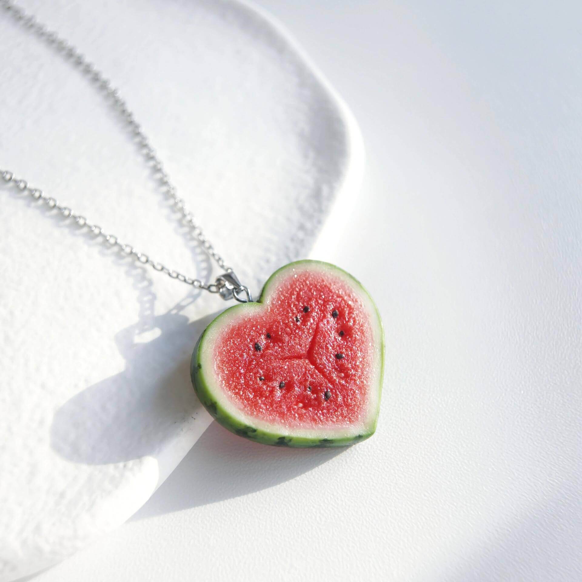 Cute realistic heart shaped watermelon slice necklace with sterling silver chain. The watermelon are made with polymer clay and then finished with a gloss varnish. The necklace are made from high-quality materials and are durable, but should not be put in aggressive environments like excessive moisture, chemicals or perfume.