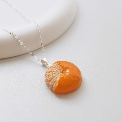 Cute realistic half-peeled tangerine necklace with sterling silver chain. The tangerine are made with polymer clay and then finished with a gloss varnish. The necklace are made from high-quality materials and are durable, but should not be put in aggressive environments like excessive moisture, chemicals or perfume.